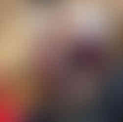 Susannah Brade-Waring facilitating a team building session, smiling warmly as she holds up a training card. She is interacting directly with participants, demonstrating an engaging, person-centred approach to leadership development.