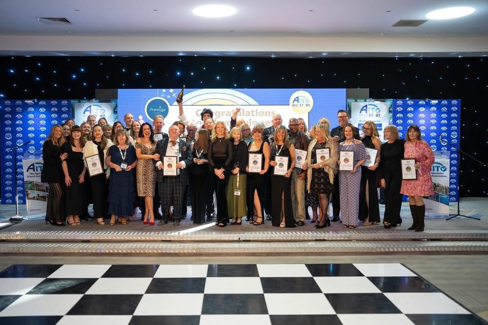 A large group of specialist travel agents celebrating on stage at the AITO Kickstart event, including the Luxury Dream Holidays team with their award certificates.