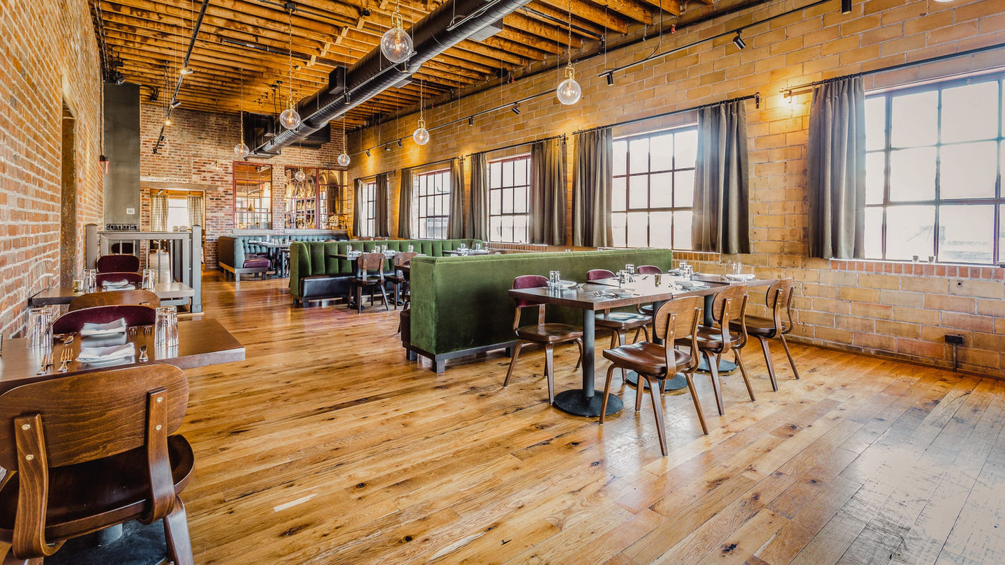 Ballard Room set up for private dining with banquet tables and large north-facing windows