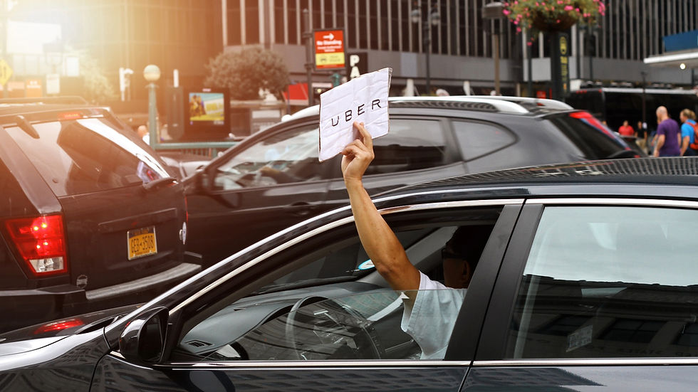 Uber driver holding a sign through car window in city traffic, symbolizing disputes over contracts and arbitration claims.