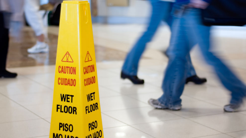 Slippery when wet caution sign with people walking nearby.