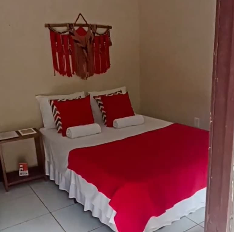Quarto com cama de casal e cobertor vermelho