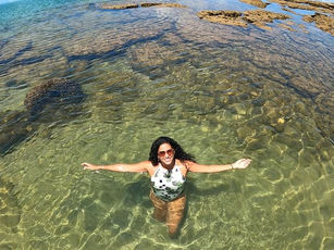 Mulher nas piscinas naturais que se formam na maré baixa