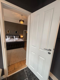 Blick aus dem Badezimmer in das Schlafzimmer bei geoeffneter Tuer