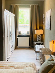 Blick vom Bett in das Ankleidezimmer mit Schrank, einem Fenster