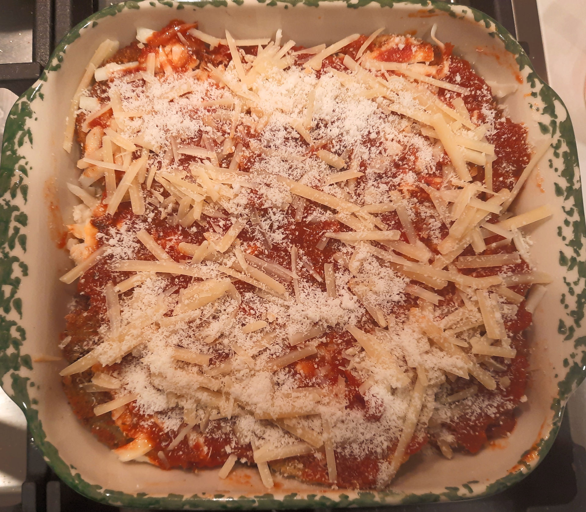 Thge final layer is sauce and shredded cheeses.