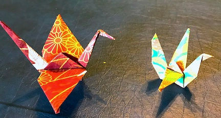 two colorful origami cranes on a table
