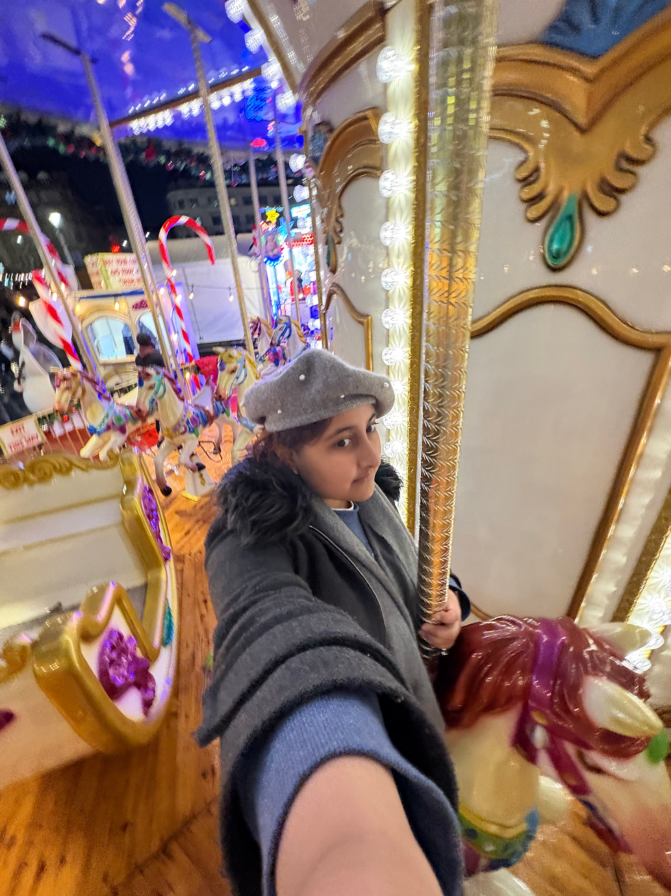 A girl in a pearl beret sitting on a carousel.
