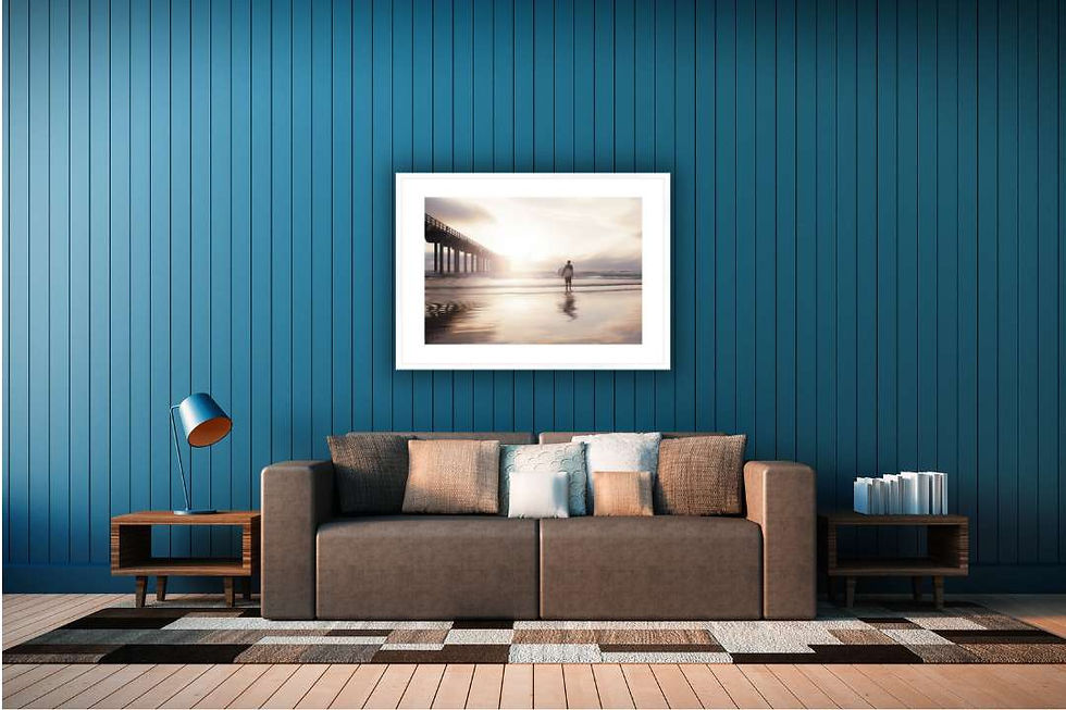 surf beach art in white frame against dark blue wall hanging above sofa