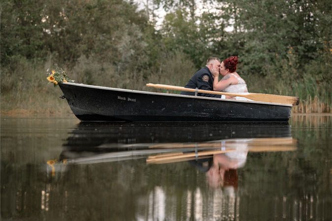Couple kissing in a canoe on calm water with reflections, a romantic moment at Calgary small wedding venues