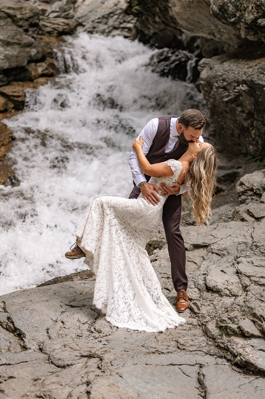 bride and groom kiss near Crowsnest Pass near many options for Airbnb wedding venues in Alberta