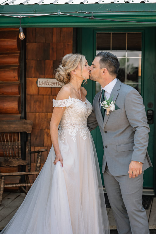bride and groom sharing a kiss outside of the Airbnb wedding venues in Alberta 