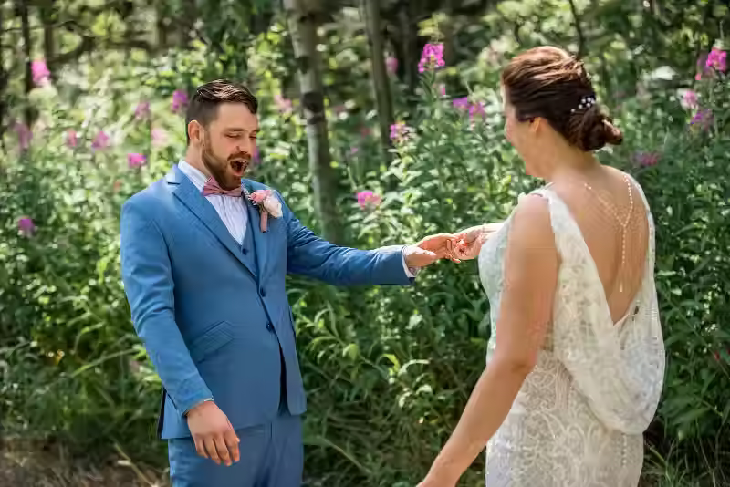 Groom looks at bride during first look wedding photos