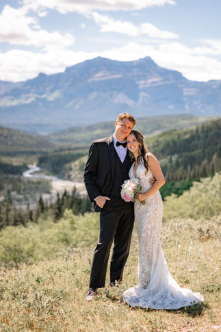 Bride and groom posing on a scenic mountain overlook, highlighting the beauty of Calgary small wedding venues