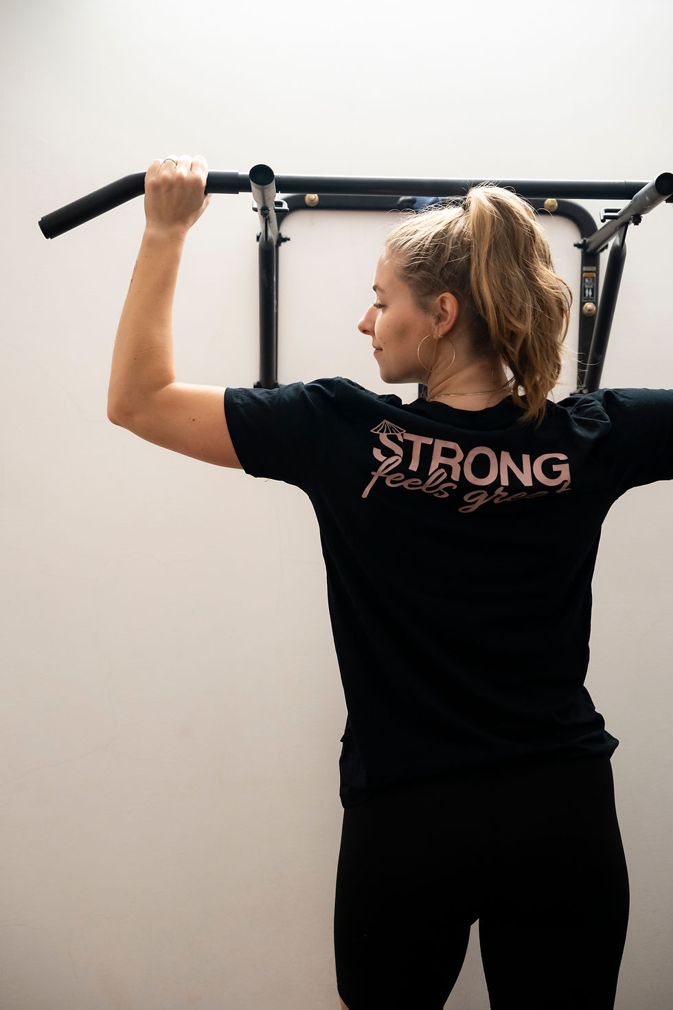Female holding on to pull up bar