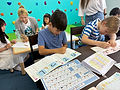 Children learning Japanese with worksheets and interactive activities at Elev8 Tokyo day camp