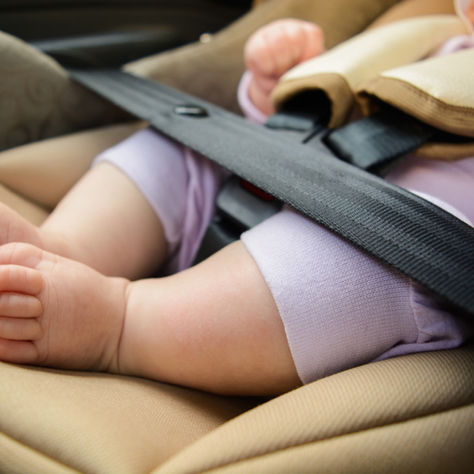 Baby in een veilig i-Size autostoeltje (babyschaal) achterwaarts bevestigd in de auto.