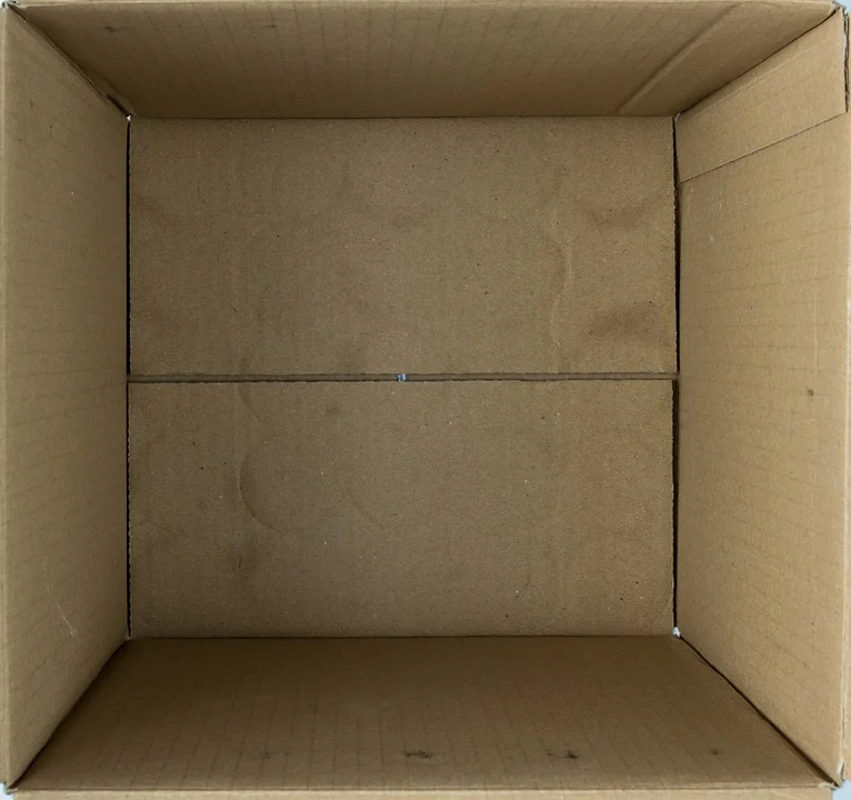 An image of the interior of a cardboard box, slightly indented and dirty from use.