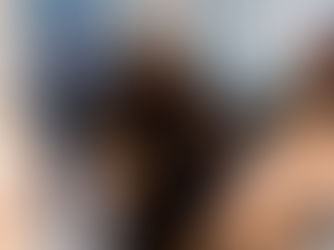 Tara Attfield-Tomes sits on a panel in a black outfit, holding a microphone and a black folder. She wears glasses and a statement necklace, and is smiling thoughtfully. Beside her is another panel speaker. Behind them, a screen displays a speaker lineup with Tara’s name visible. The image captures Tara’s presence as a confident leader and changemaker in the funding and entrepreneurship ecosystem.