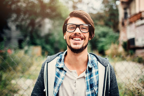 Smiling man with brown hair and glasses.
