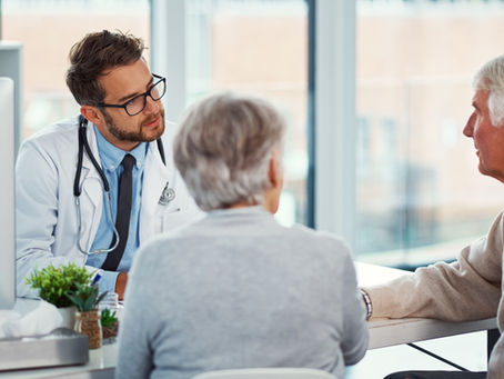 Doctor discussing a dementia diagnosis with an older couple and their family, representing education, assessment, and compassionate support for memory-related conditions.