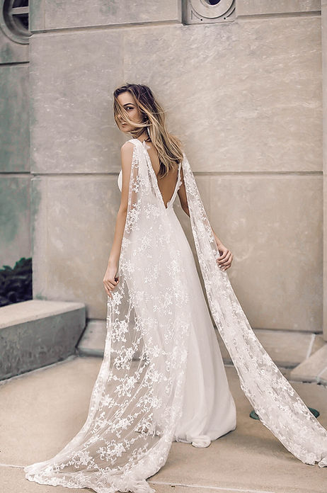The fairy wing cape of the Clemnce gown by Flora & Lane on full display.