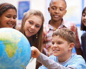 Here it is - Geography class. A group of pupils looking at a globe during geography class.