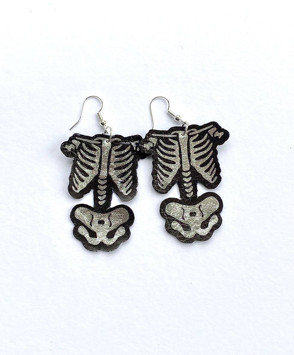 Silver skeleton body earrings on silver plated hooks. Silver bones on black backing.