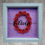 Thumbnail: Rolled Red Paper Flowers on a glitter purple background with Black overlayed name in a grey frame