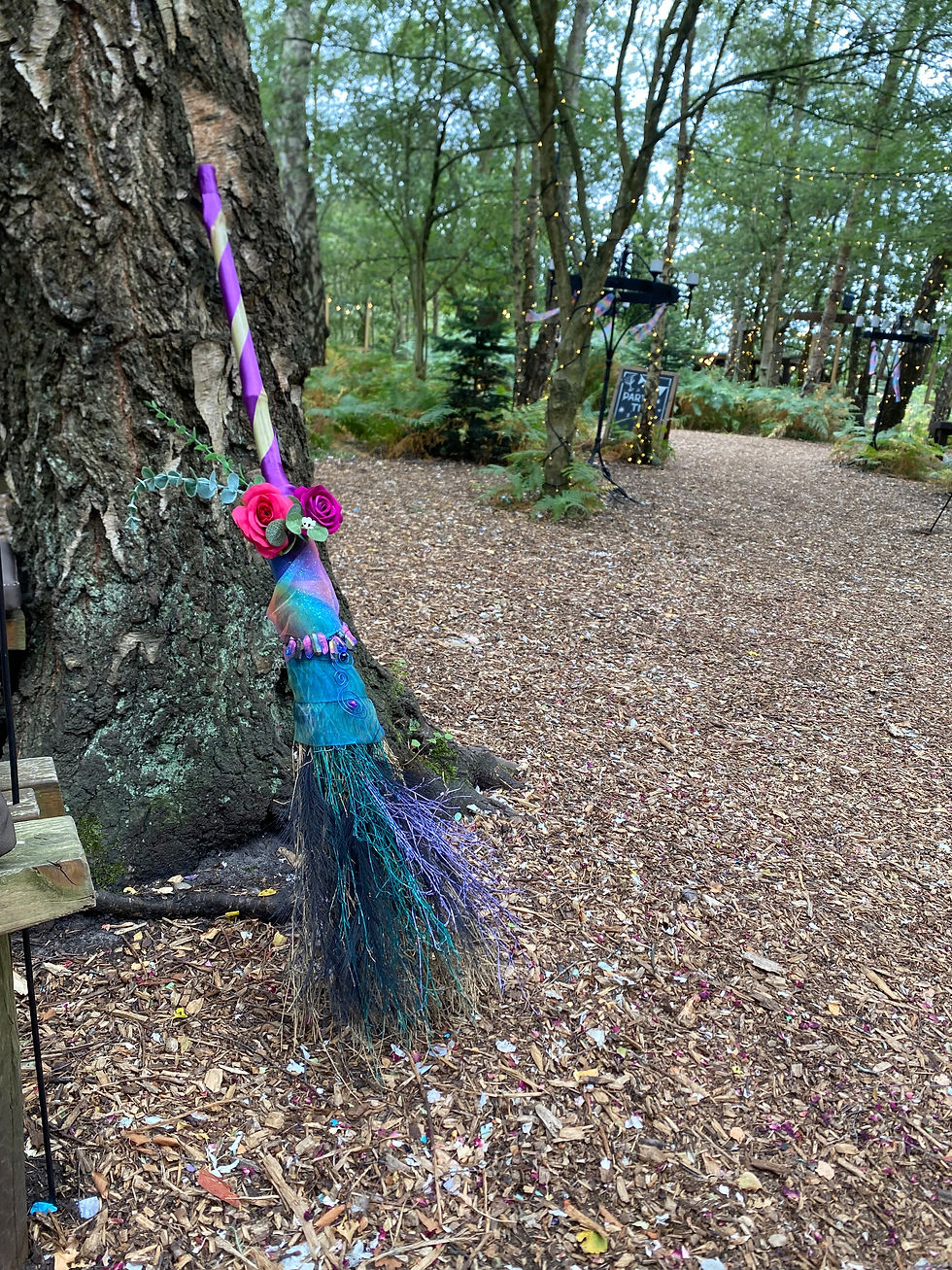 A broomstick leaning against a tree at a wedding ceremony