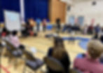 people sitting in a circle in a school gym