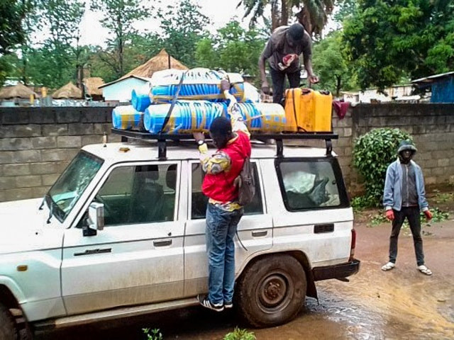 an image is shown of three people putting things on top of a white car