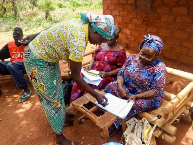 an image is shown of four people talking and taking notes