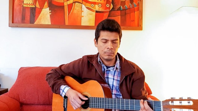 man playing guitar on a red couch with his eyes closed