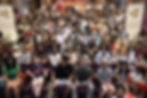 an image of a large audience all sitting together smiling for the photo