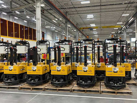 a row of forklifts in a factory setting.
