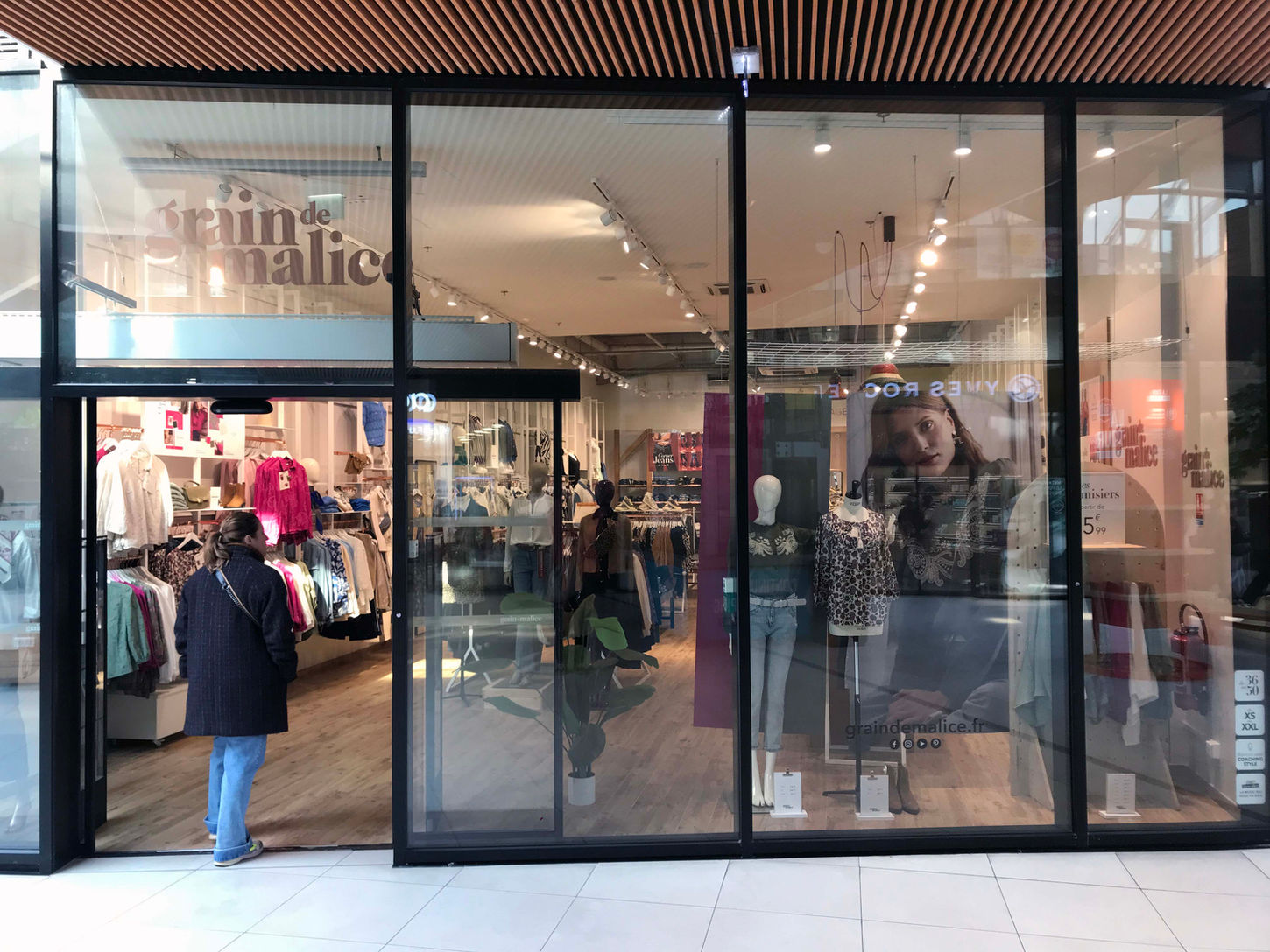Scénographie colorée de la vitrine Grain de Malice avec le dispositif Bar à Chemisiers pour le lancement de la collection.