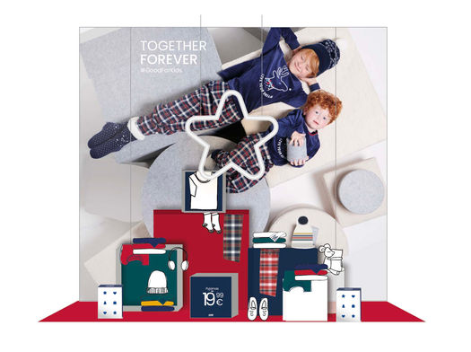 Scénographie de vitrine de Noël Okaïdi avec un empilement créatif de boîtes en carton de différentes dimensions.