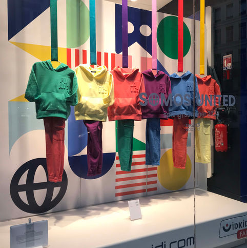 Scénographie de vitrine Okaïdi pour la collection Printemps-Été 2024 basée sur le concept du drapeau universel.