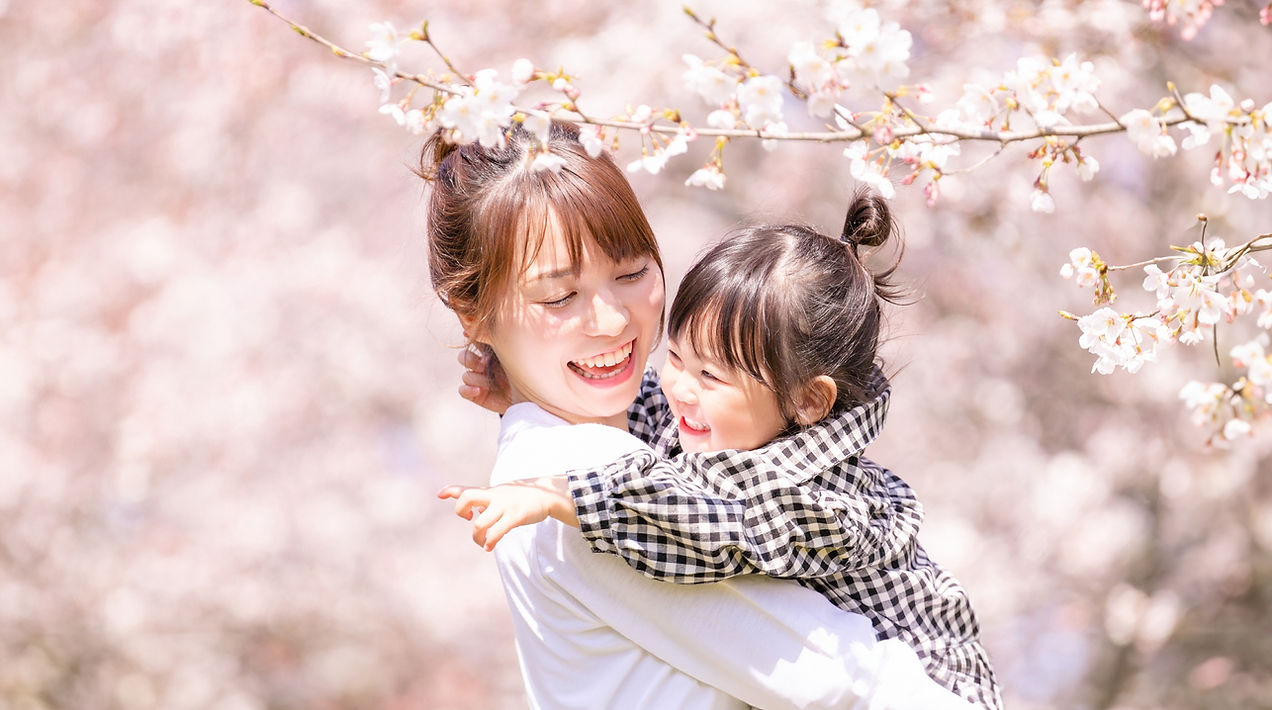 桜の花の下で笑顔の親子