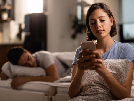 Woman using her phone while emotionally distant from her partner