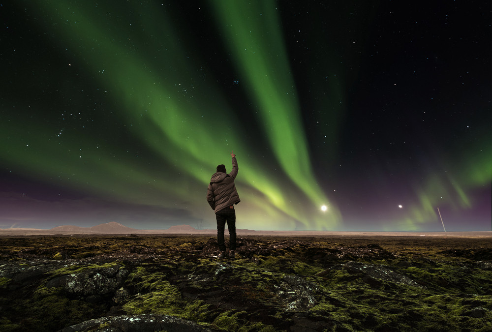 Turista disfrutando de las auroras boreales en Islandia