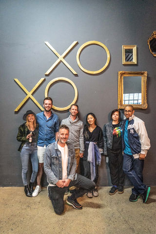 Diverse group of friends smiling and posing together in an indoor axe throwing venue in Cape Town.