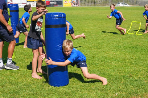 Rugby Coach at rugby Champs training camp kids tackling 