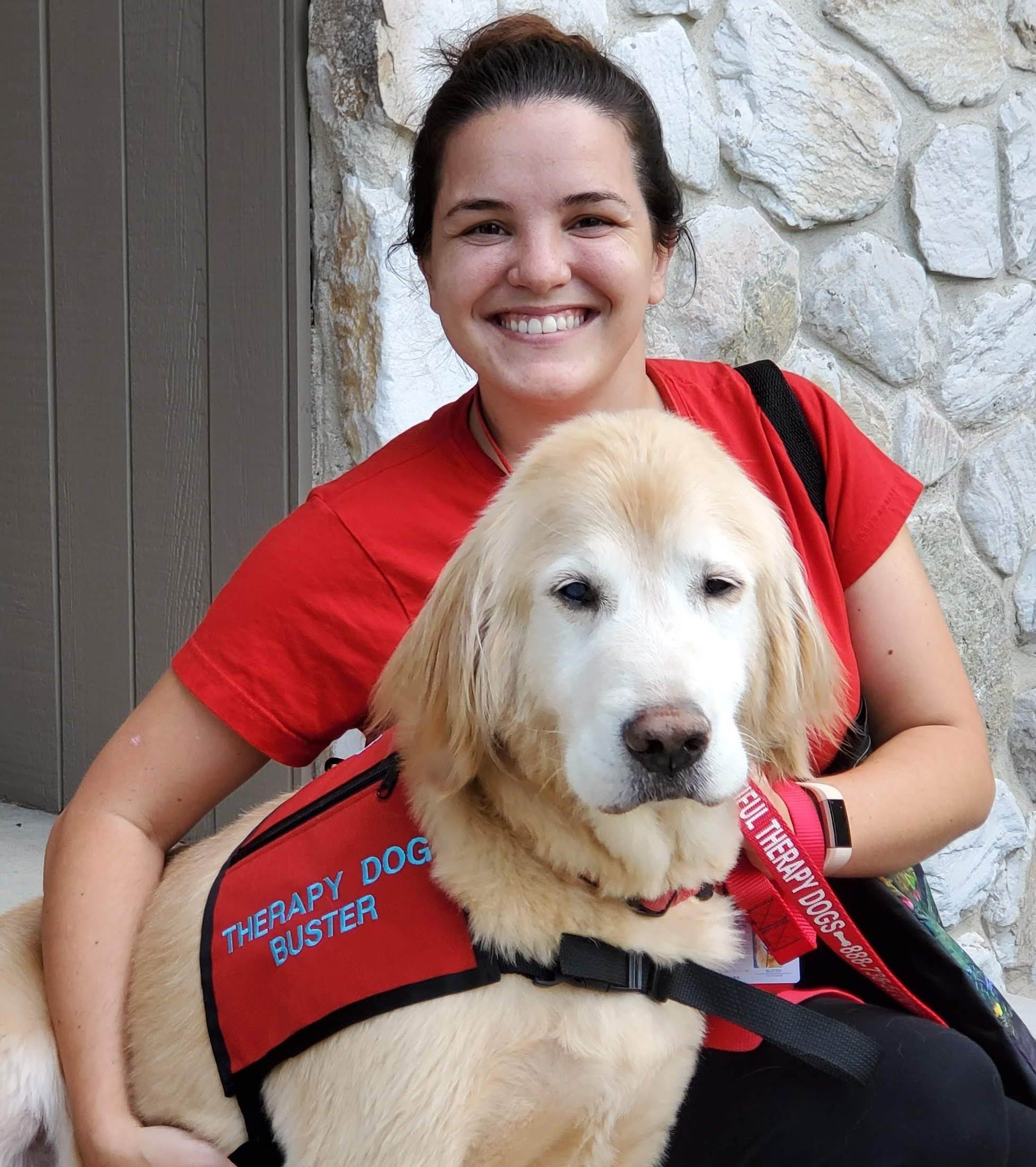 Christina smiling with therapy dog Buster