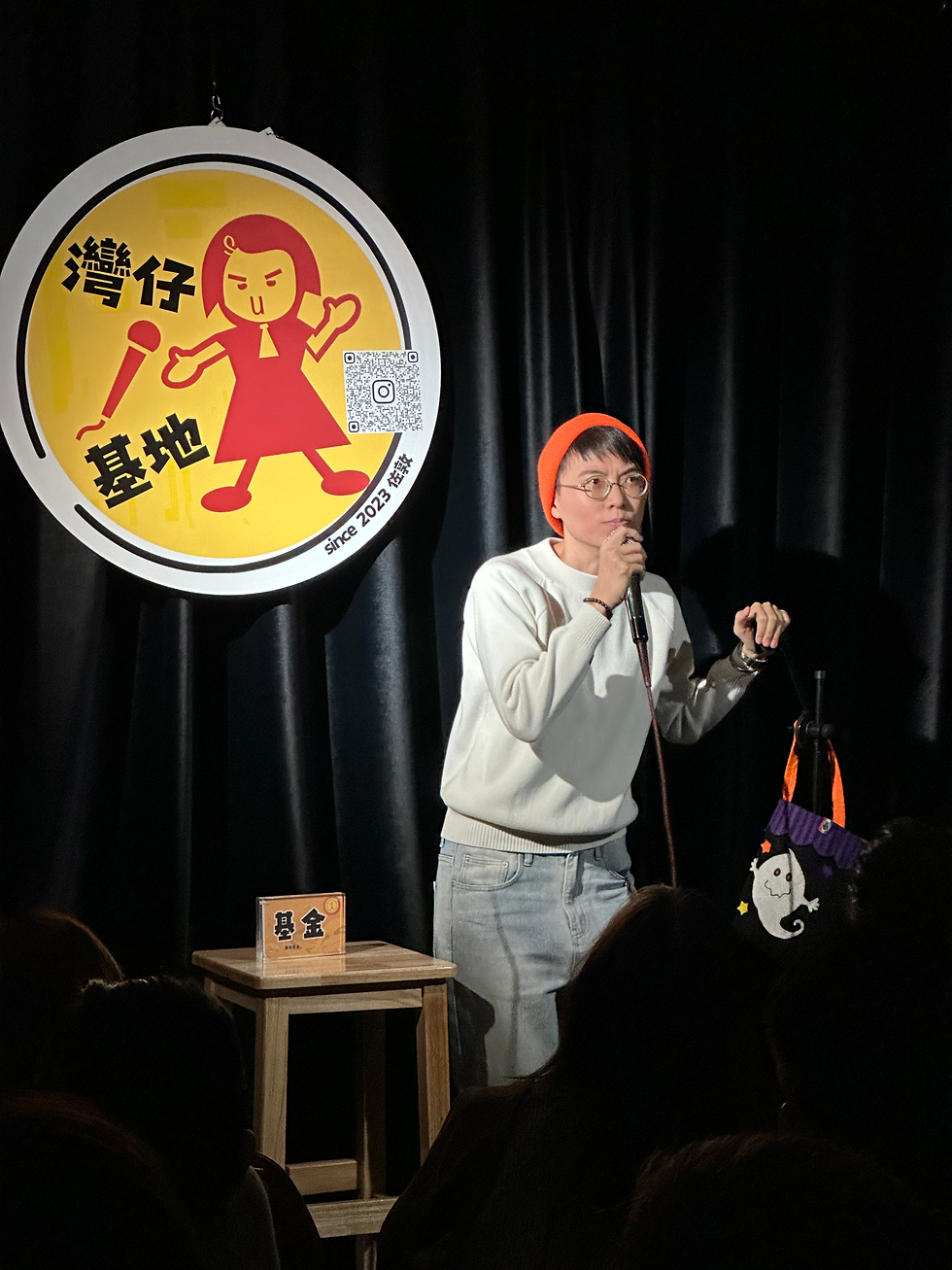 student performs stand up comedy on stage