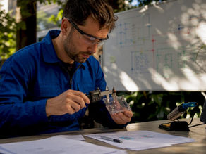 Scientist measuring supercapacitor module in lab