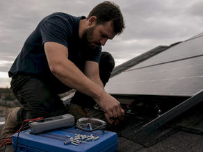 Homeowner inspecting rooftop solar panel wiring