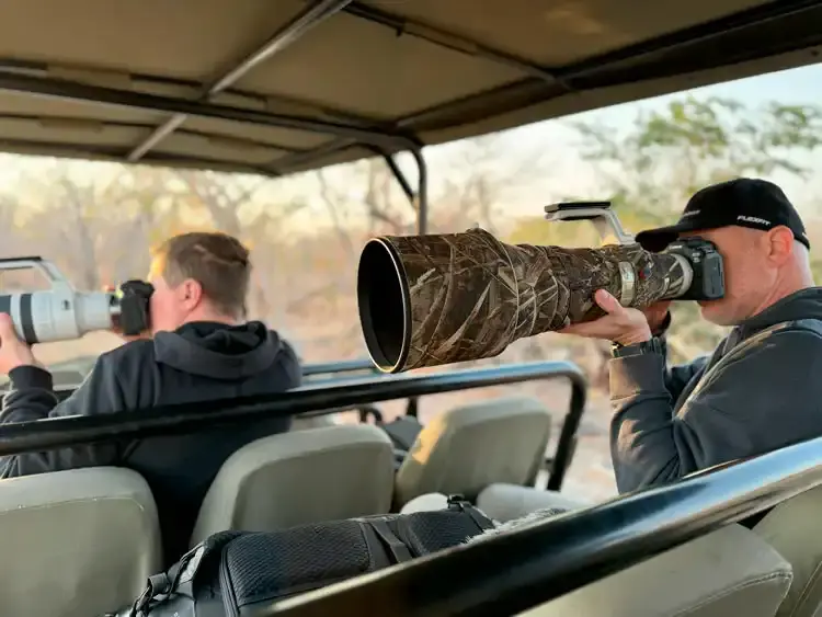 Photographers in a safari vehicle capturing wildlife on a luxury African photo safari