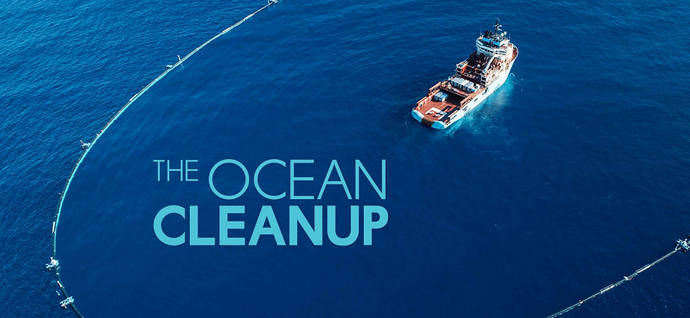 Photo of volunteers on a coastal clean-up beach, holding bags of collected plastic bottles, against an ocean background.